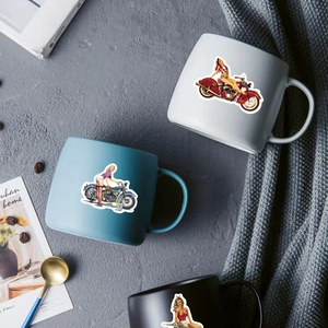 Retro motorcycle pin-up girl stickers displayed on stylish ceramic mugs in home setting