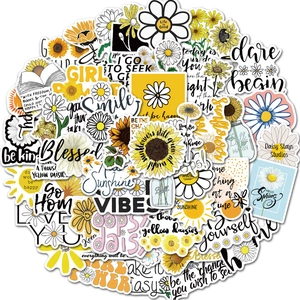Close-up of sunflower and daisy stickers with motivational quotes for laptops