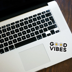 Waterproof Good Vibes daisy sticker applied on a silver laptop for stylish decoration
