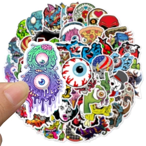 Close-up showing a hand holding a colorful skull monster sticker from the 50-piece DIY set