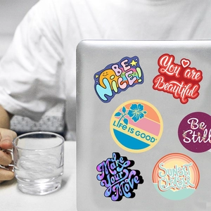 Close-up of waterproof inspirational vinyl decals applied on a silver laptop lid