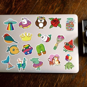 Detail of colorful cartoon stickers like unicorn and cat on a silver laptop lid