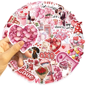 Gros plan d'une main tenant un autocollant en forme de cœur de la collection Saint-Valentin