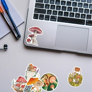 Detailed view of mushroom theme decorative stickers on a desk with laptop and notebook