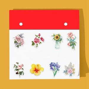 Detailed view of floral scrapbooking stickers with roses and sunflowers on yellow background