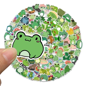 Close-up of cute cartoon frog stickers being held, showing waterproof PVC texture