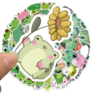 Close-up of a waterproof cartoon frog sticker held by hand with assorted designs