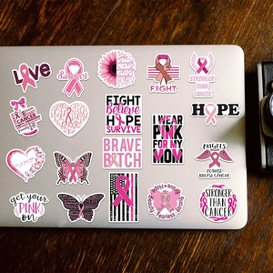 Pink ribbon breast cancer awareness stickers displayed on a silver laptop lid
