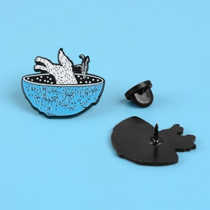 Broche en émail avec un chien blanc dans un bol bleu et fermoir papillon en métal