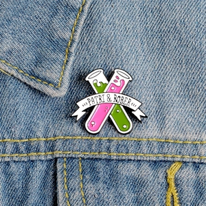 Creative enamel pin featuring laboratory test tubes pinned on light blue denim jacket