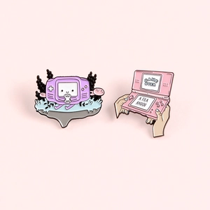 Cartoon handheld game console enamel pins featuring purple and pink retro consoles