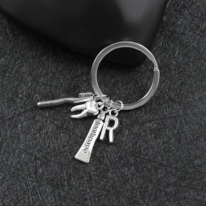 Vista macro del portachiavi dentale in argento con spazzolino e ciondoli a dente