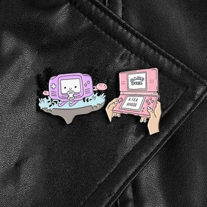 Macro view of GBA and NDS game console enamel pins pinned on a black leather jacket