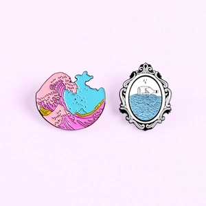 Detail of enamel pin set featuring Ukiyo-e style pink waves and a ship in a bottle design