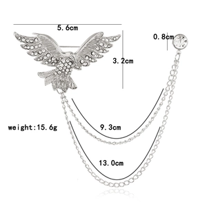 Vue détaillée de la broche aigle argentée avec strass brillants et doubles chaînes fines
