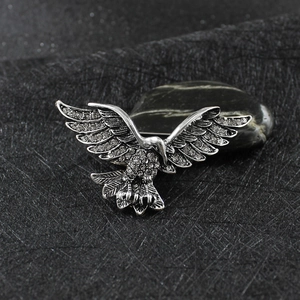 Détail macro d'une broche aigle avec strass blancs scintillants sur métal argenté