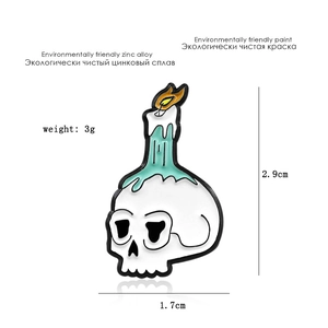 Detail view of skull candle enamel pin showing 2.9cm x 1.7cm dimensions and 3g weight