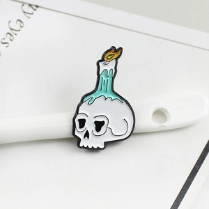 Skull with melting green candle enamel pin in a white porcelain spoon display