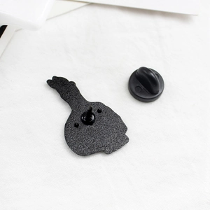 Black enamel skull candle brooch back detail with durable rubber clutch pin backings