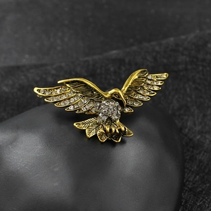 Broche aigle en or vintage ornée de strass blancs brillants sur une pierre noire