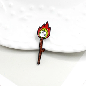 Creative enamel pin showing an outdoor campfire roasting marshmallows on white ceramic