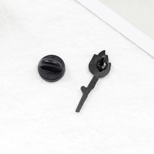 Detail of creative candle flame brooch showing black metal back and rubber pin clutch