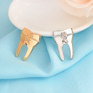 Detailed view of gold and silver tooth-shaped pins on a light blue striped fabric background