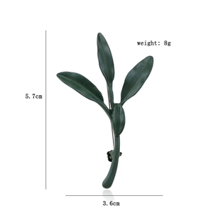 Detailed view of dark green leaf brooch with dimensions 5.7cm by 3.6cm and weight 8g
