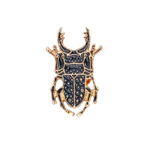 Exquisite beetle insect brooch with gold plating and black enamel polka dots on white background