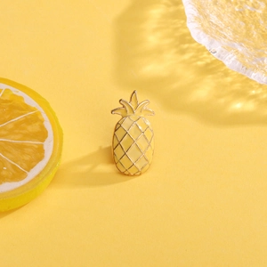 Cute yellow enamel pineapple brooch with gold metal lines on bright yellow background