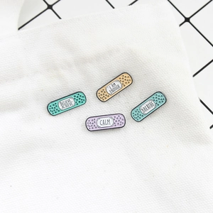 Creative band-aid enamel pins set with motivational quotes on a white canvas