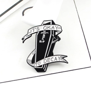 Gothic black coffin enamel pin with RIP cross and It's Okay to Decay ribbon design