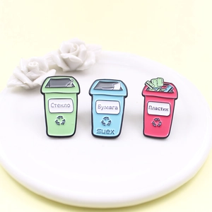 Three colorful recycle bin enamel pins for sorting glass, paper, and plastic waste