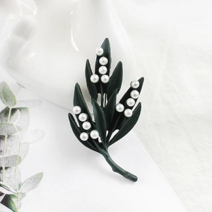 Broche feuille d'érable élégante vert foncé mat avec perles sur fond de tissu clair