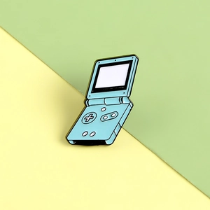 Retro-Emaille-Pin in Blau mit Gameboy-Design auf lebhaftem zweifarbigem Hintergrund