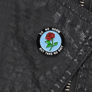 Enamel brooch with red rose and Do No Harm Take No Shit text on black leather jacket