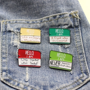 Set of four colorful enamel greeting card pins on blue denim fabric background