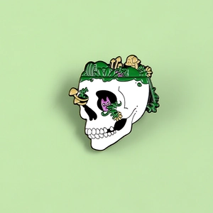 Artistic cat skull enamel pin with green plants and tiny mushrooms accessory