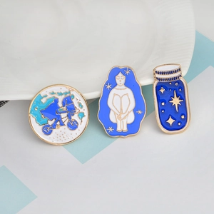 Three creative enamel brooches featuring cycling silhouette and starry bottle motifs