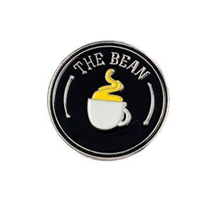 Enamel coffee brooch featuring THE BEAN text and white cup design on black background
