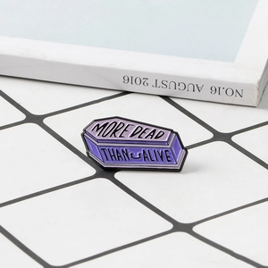 Gothic style purple coffin enamel pin with More Dead Than Alive letter design