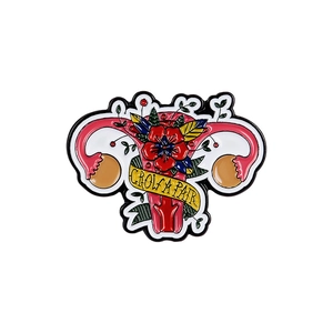 Enamel uterus brooch with flowers and GROW A PAIR text on a yellow ribbon badge