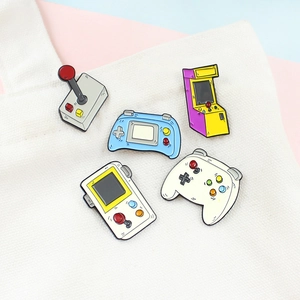 Set of five retro gaming enamel pins including controllers and arcade machines on canvas bag