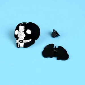 Gothic skull and female face enamel pin with butterfly clasp on blue background