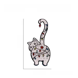 Détail de la broche chat en émail blanc avec des lumières de Noël colorées et paillettes