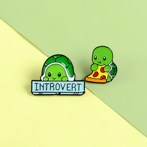 Cartoon turtle enamel pin set with introvert sign and pizza slice on a bicolor background