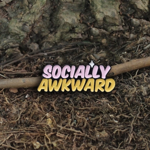 Colorful 3D Socially Awkward enamel pin badge featuring bold yellow and pink letters