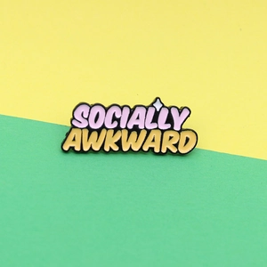 Colorful 3D enamel pin with Socially Awkward text and star on green and yellow background