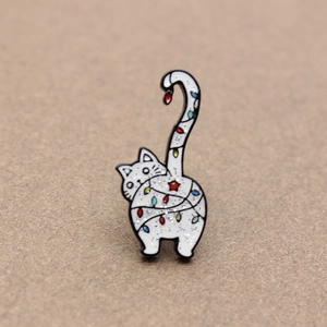 Détail d'une broche chat en émail avec guirlandes de Noël colorées et fini pailleté