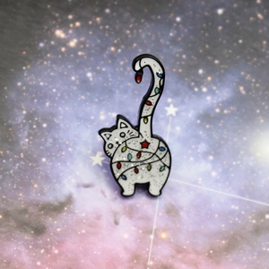 Détail de la broche chat blanc en émail avec guirlandes lumineuses et finitions pailletées